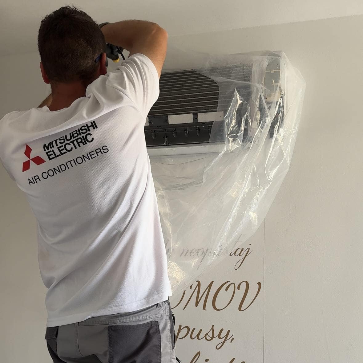 Hĺbkové čistenie klimatizácie Mitsubishi Electric po troch rokoch 1 Technik GreenHeat pri čistení vnútornej jednotky Mitsubishi Electric s ochranným vakom