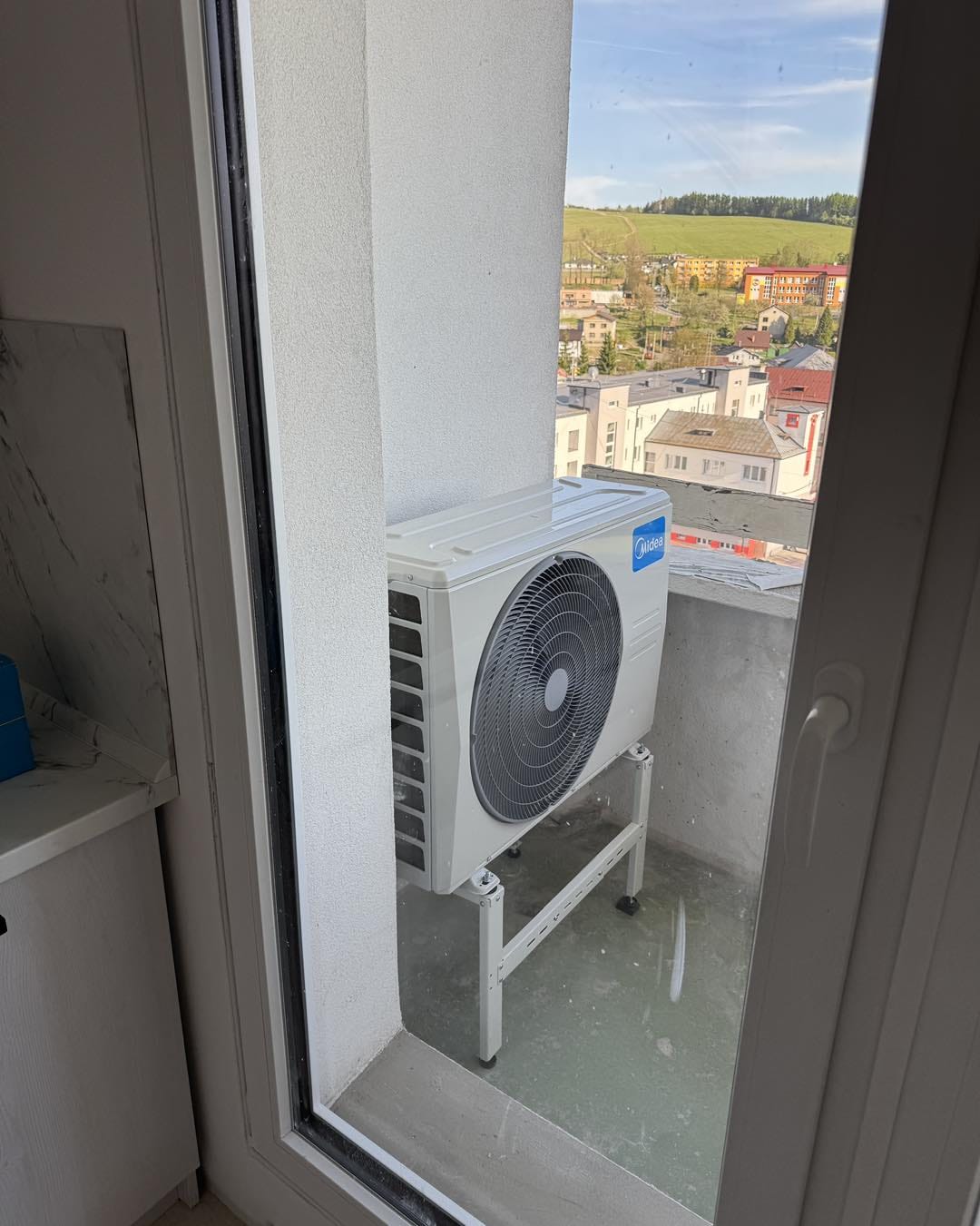 O nás 2 Vonkajšia jednotka Midea na podlahovom stojane na úzkom balkóne